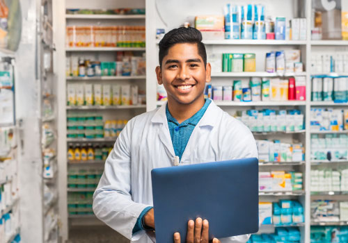 estudiante de farmacia de Zegel con anaqueles de medicamento