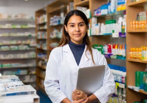 estudiante de farmacia de Zegel con anaqueles de medicamento